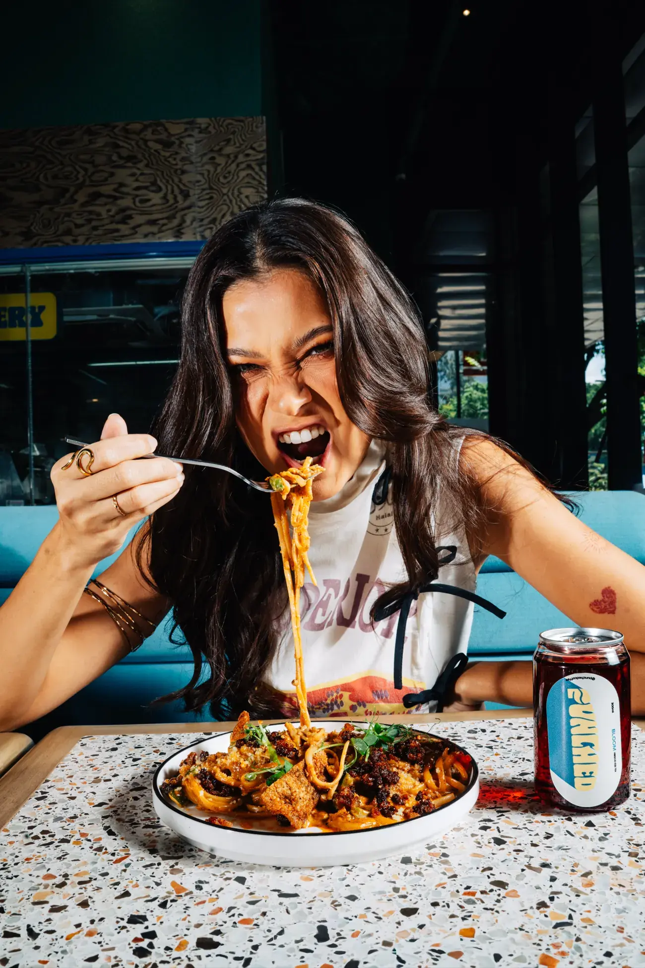 Food creator digging into a plate of pasta at Punched Coffee